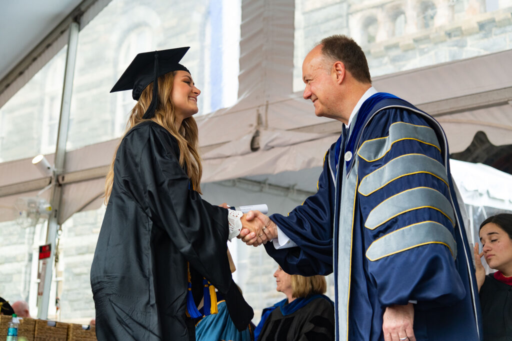 MBA student shaking hands with Georgetown President Jack Degioia during commencement