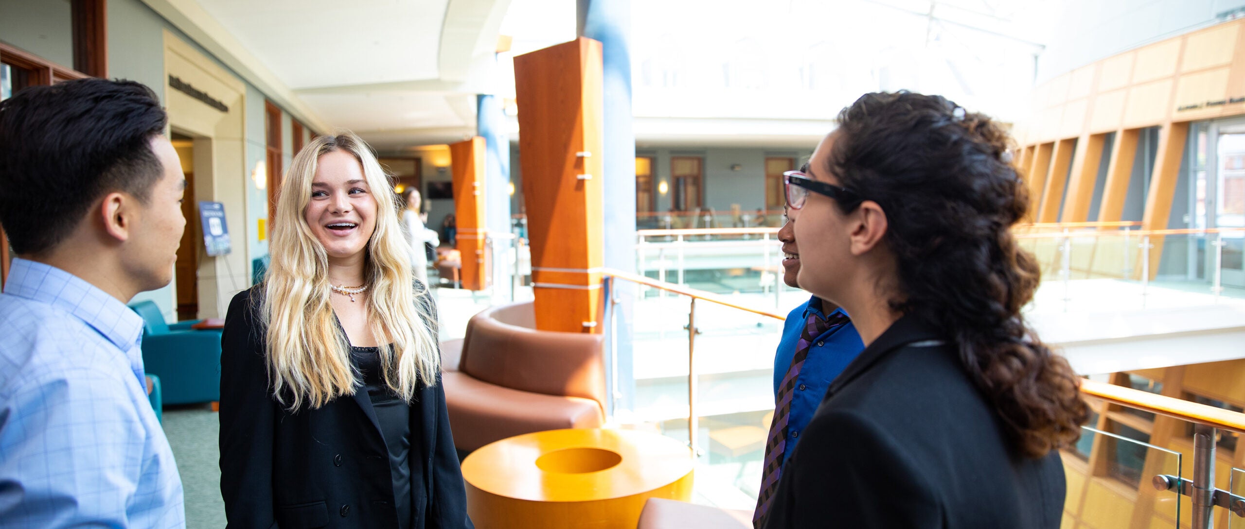 4 MiM students talking on the top floor of Hariri