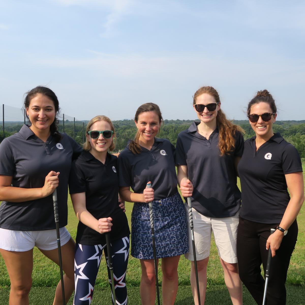 5 EMBA students in golf attire on golf course