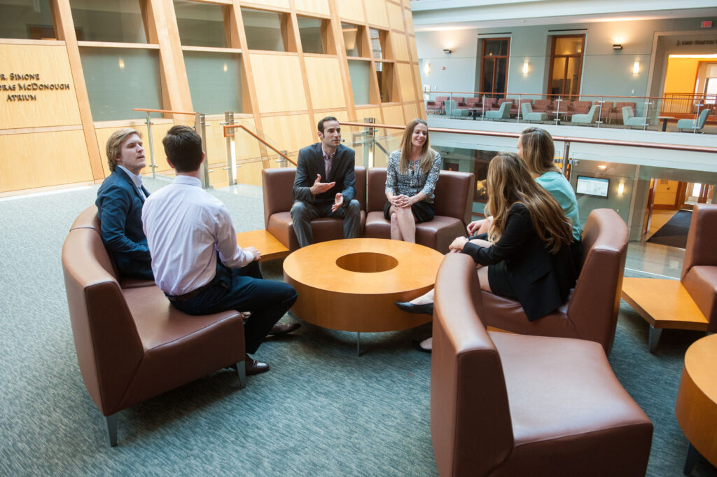 Executive Education team in group circle in hariri atrium