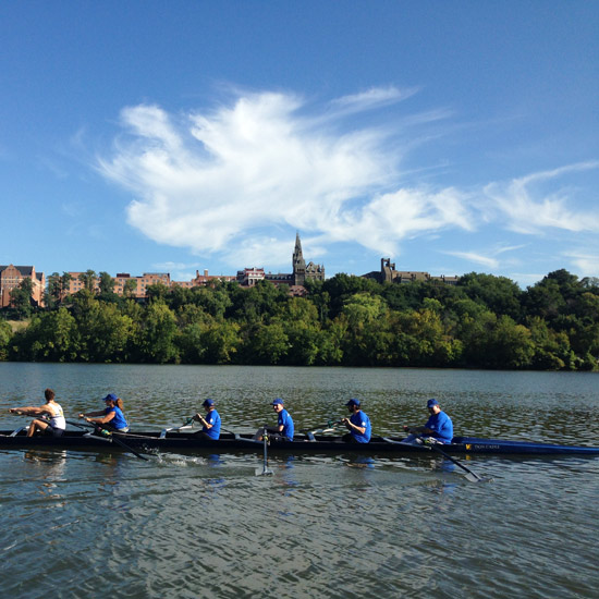 crew team rowing on potomac with georgetown university in the background
