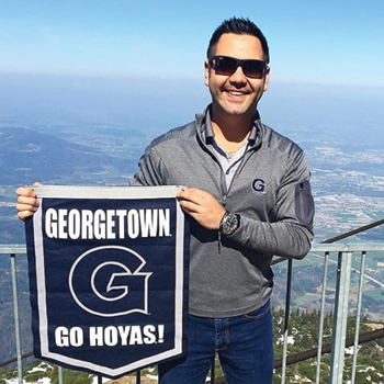 EMBA Student holding Georgetown flag