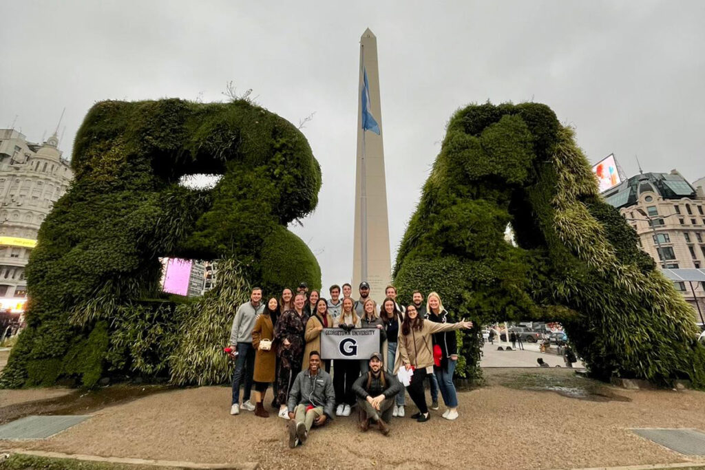 Flex MBA Students posing in front of BA letters and obelisk in Buenos Aires, Argentina