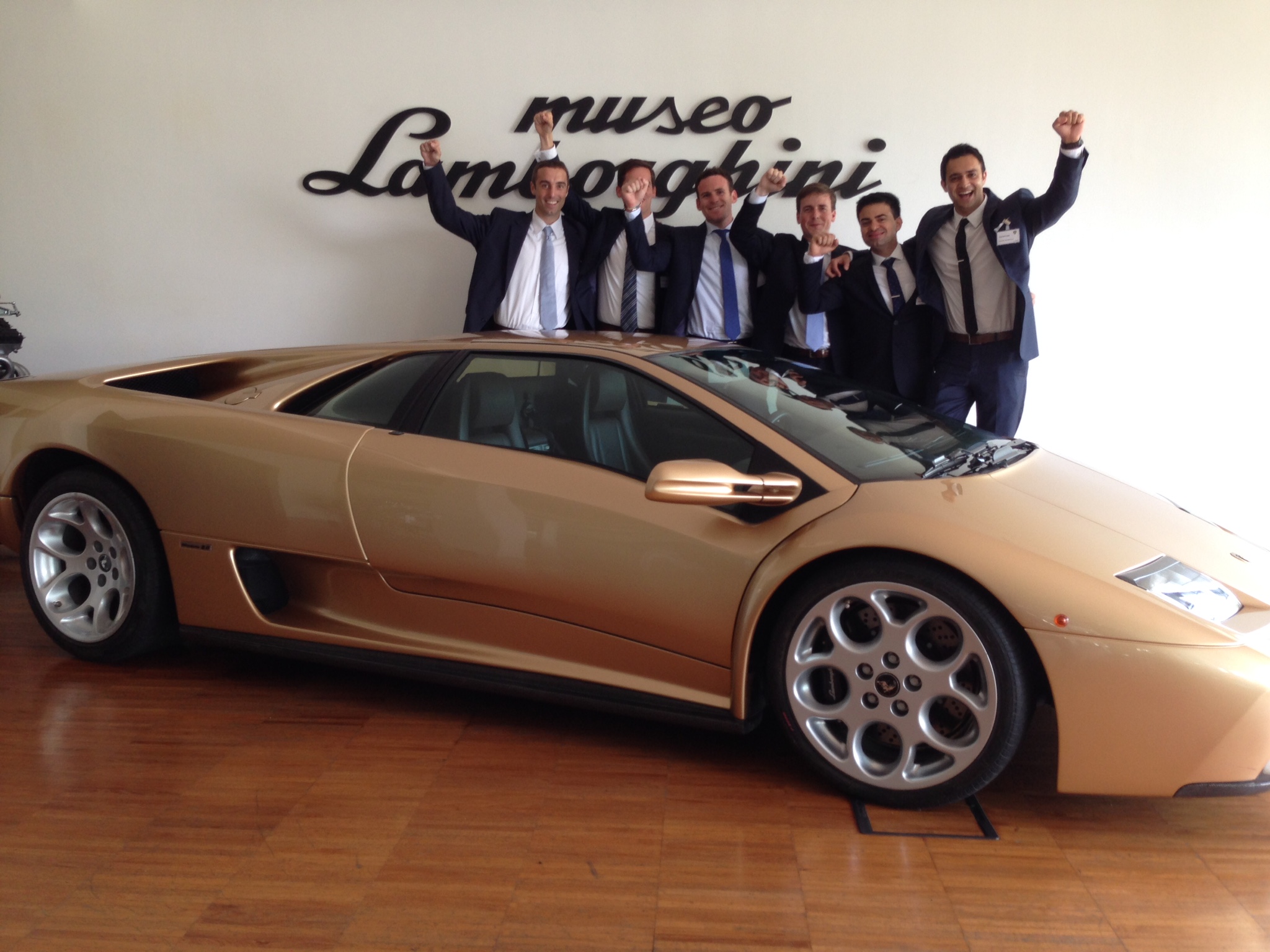 Lamborghini and Undergraduate students behind it with arms raised