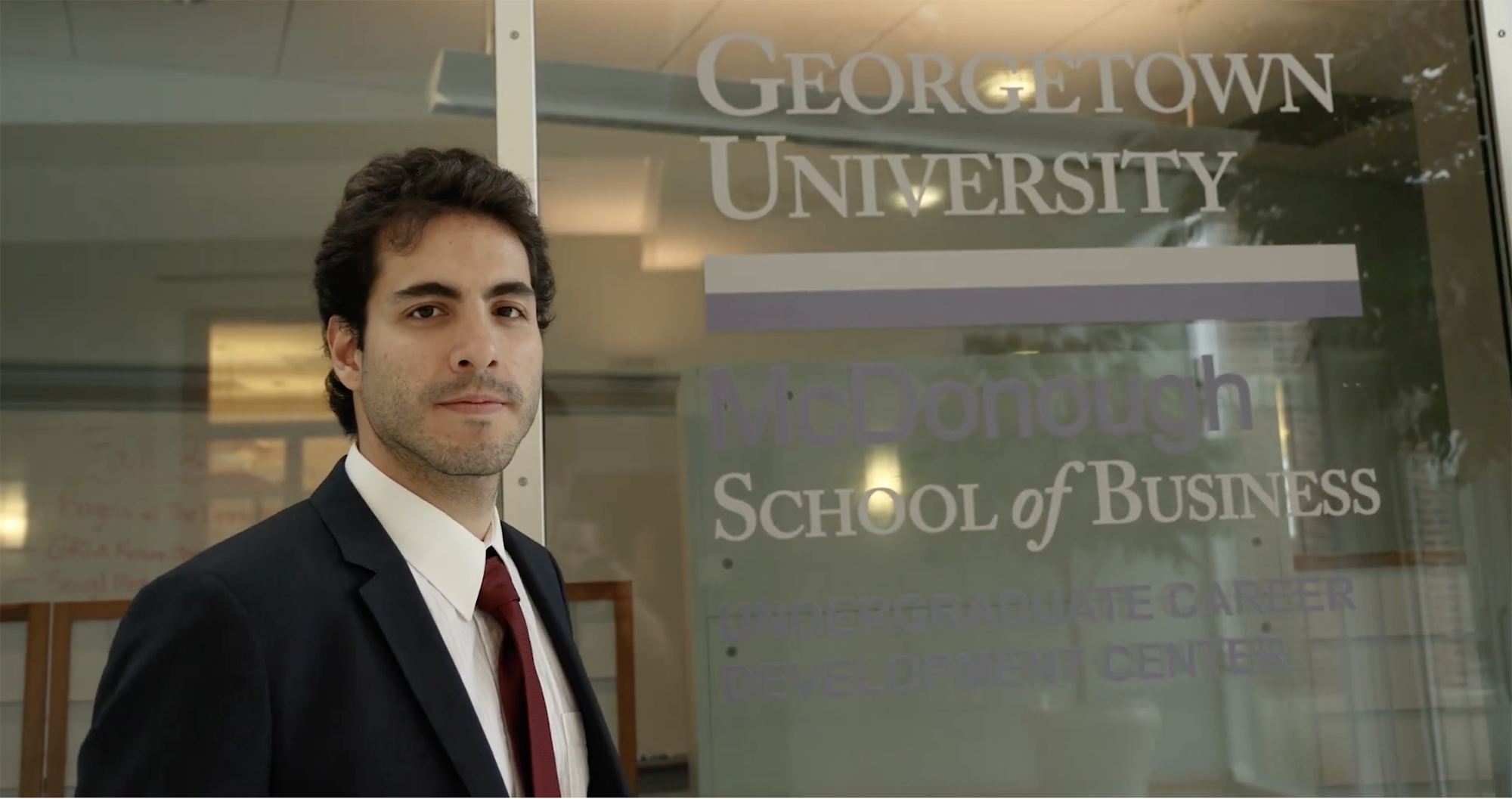 student standing in front of Georgetown McDonough School of Business Career Center sign