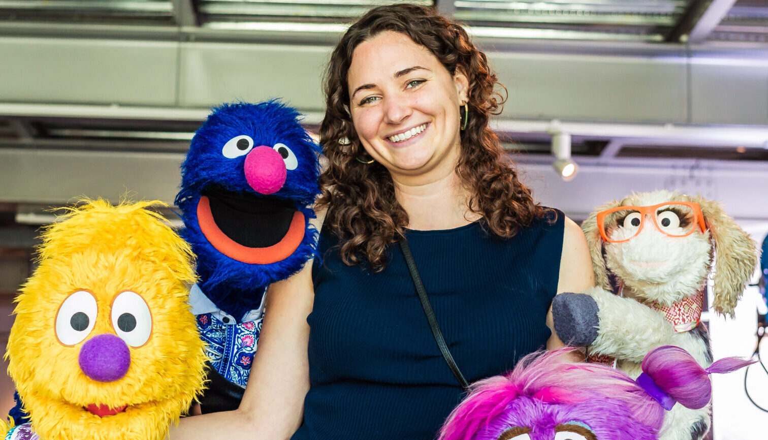 Dian Masri (MiM'20) surrounded by colorful smiling muppets