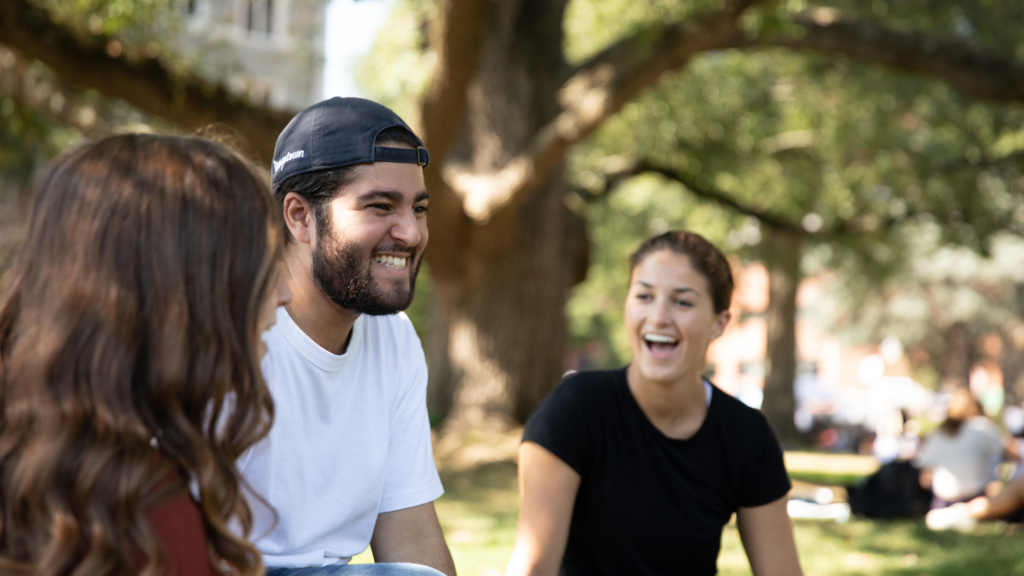 students smiling outdoors on the Healy Lawn.