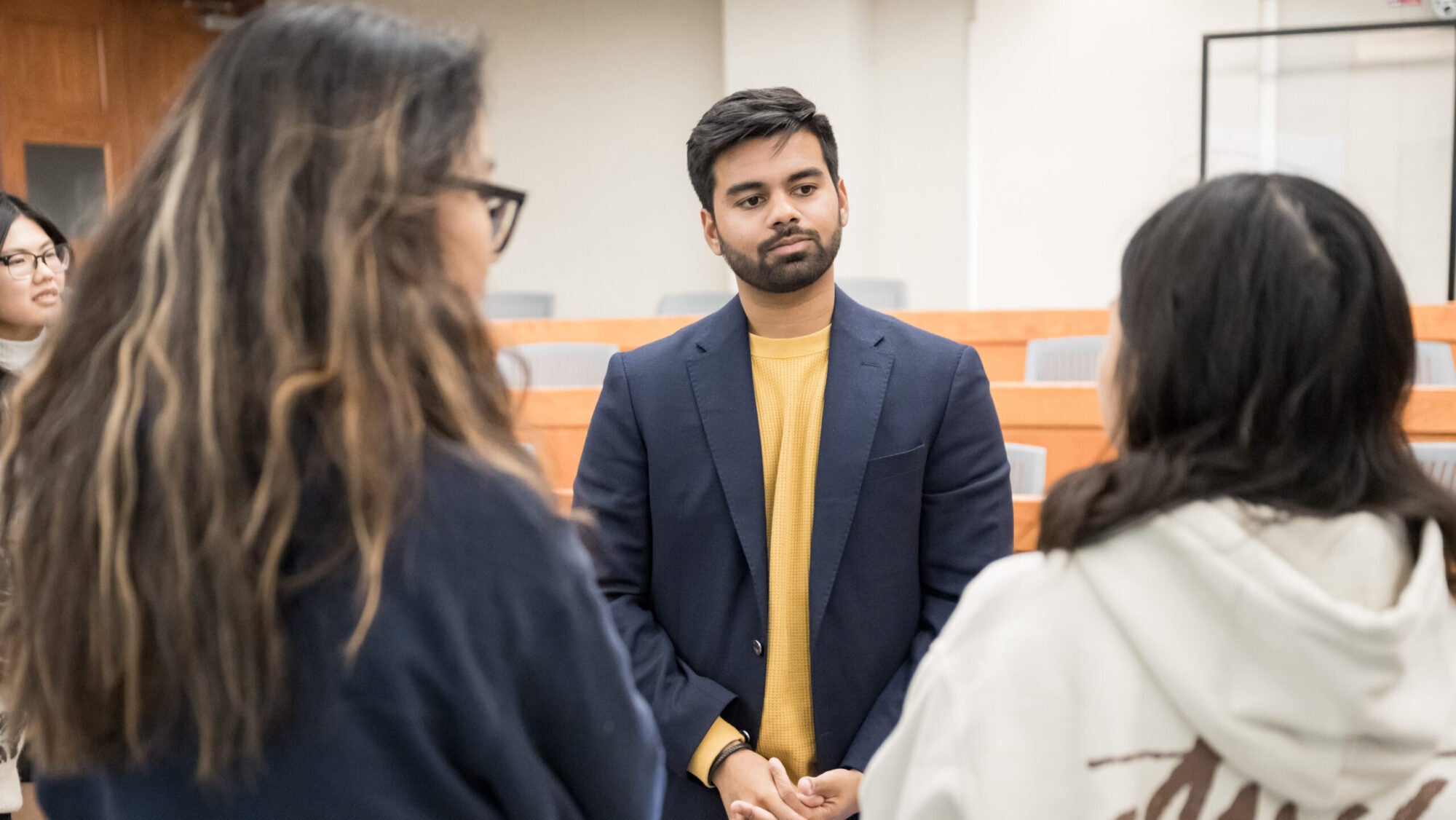 speaker standing and speaking with 2 event attendees