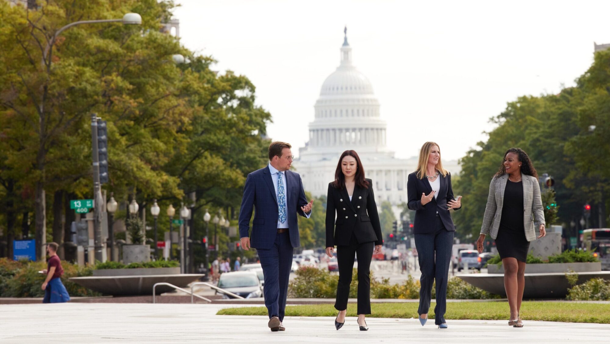 Executive MBA (EMBA) students walking in front of the capital in suits