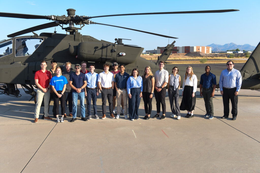 Hogan and his fellow Boeing interns pose in front of a helicopter during a company event. 