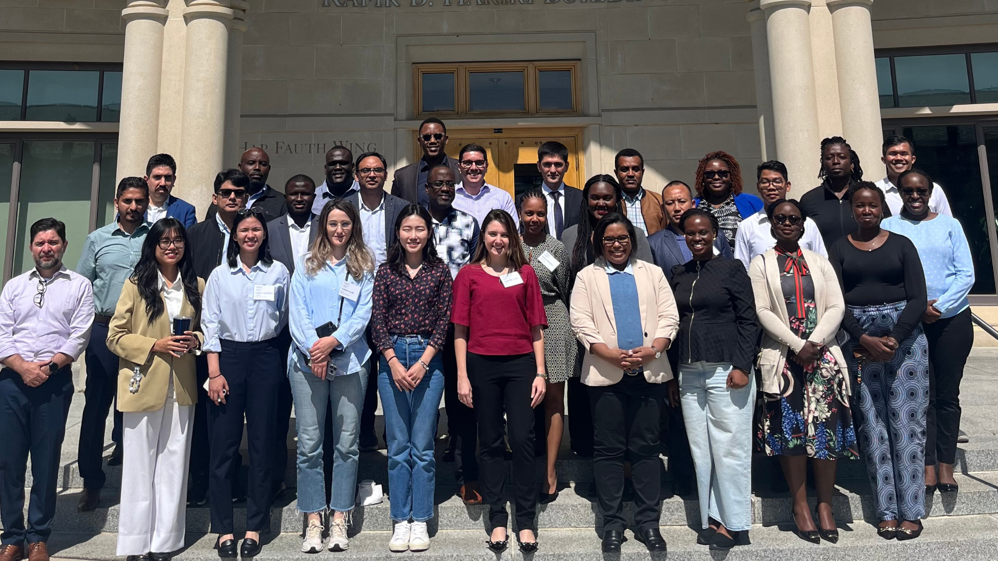 Participants of the 2024 IFC-Milken Capital Markets Program standing outside the Rafik B. Hariri Building at Georgetown University