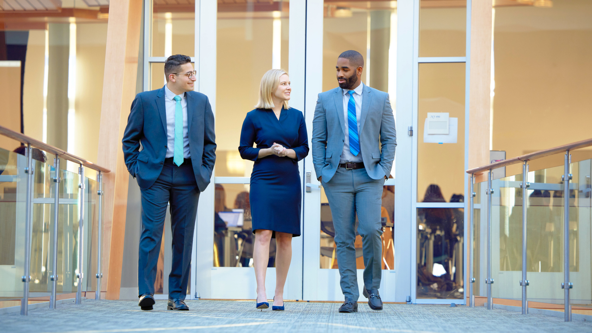 Three Georgetown MBA students walking through the Rafik B. Hariri Building.