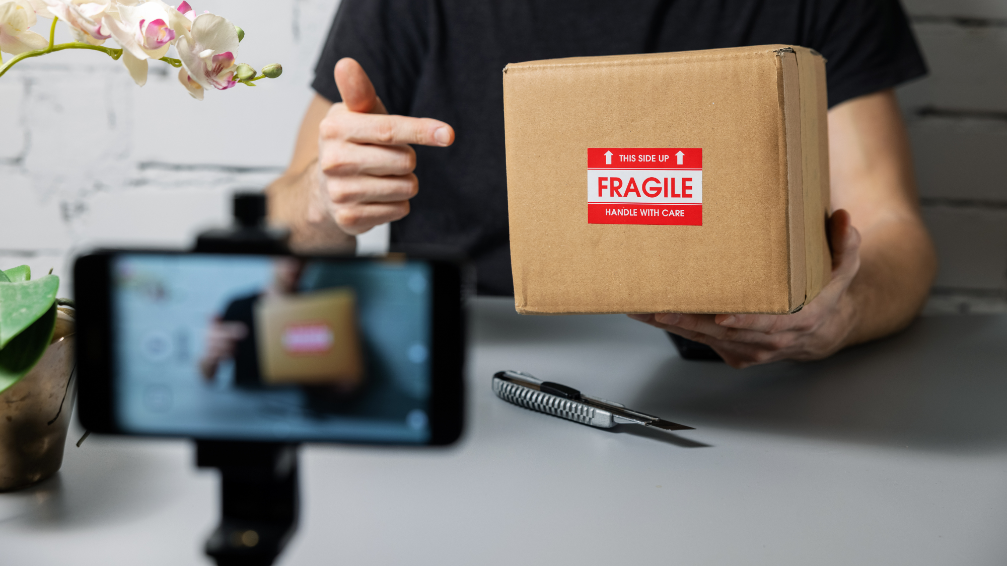 Influencer holding up package while filming a video