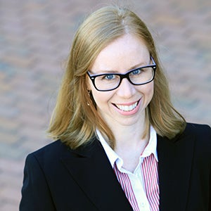 student raye powell wearing glasses and a sharp black jacket