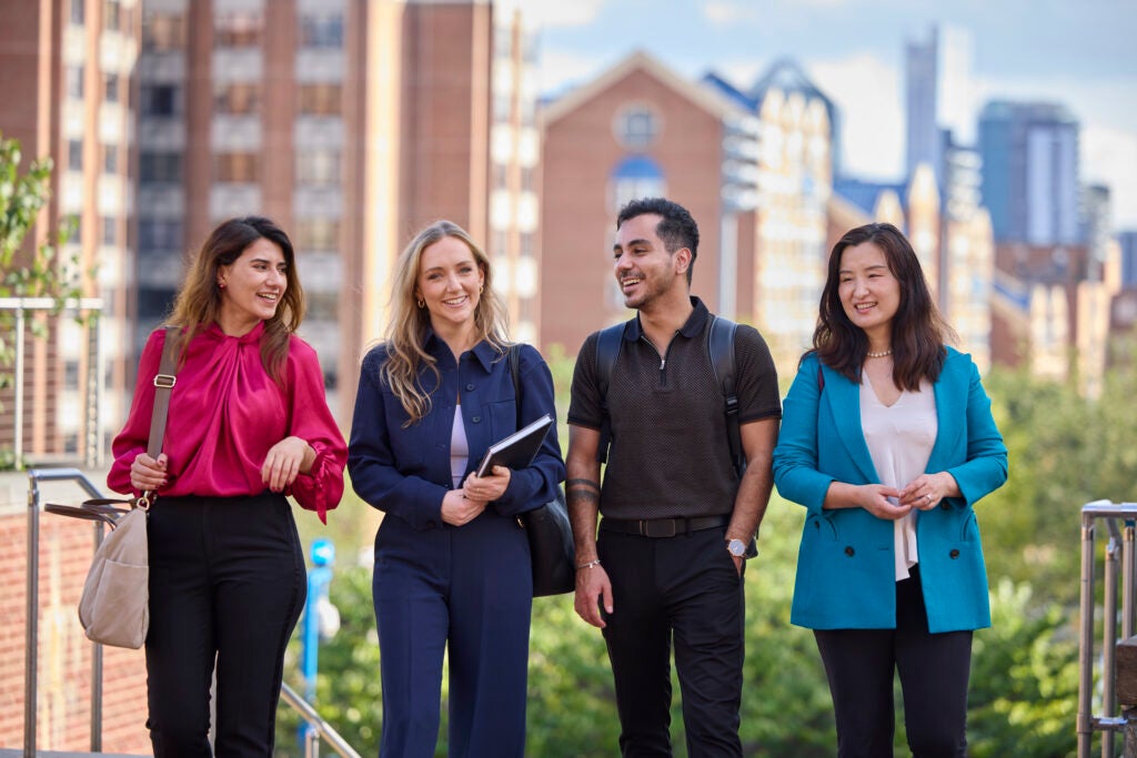 group of four georgetown university students talking outside the hariri building