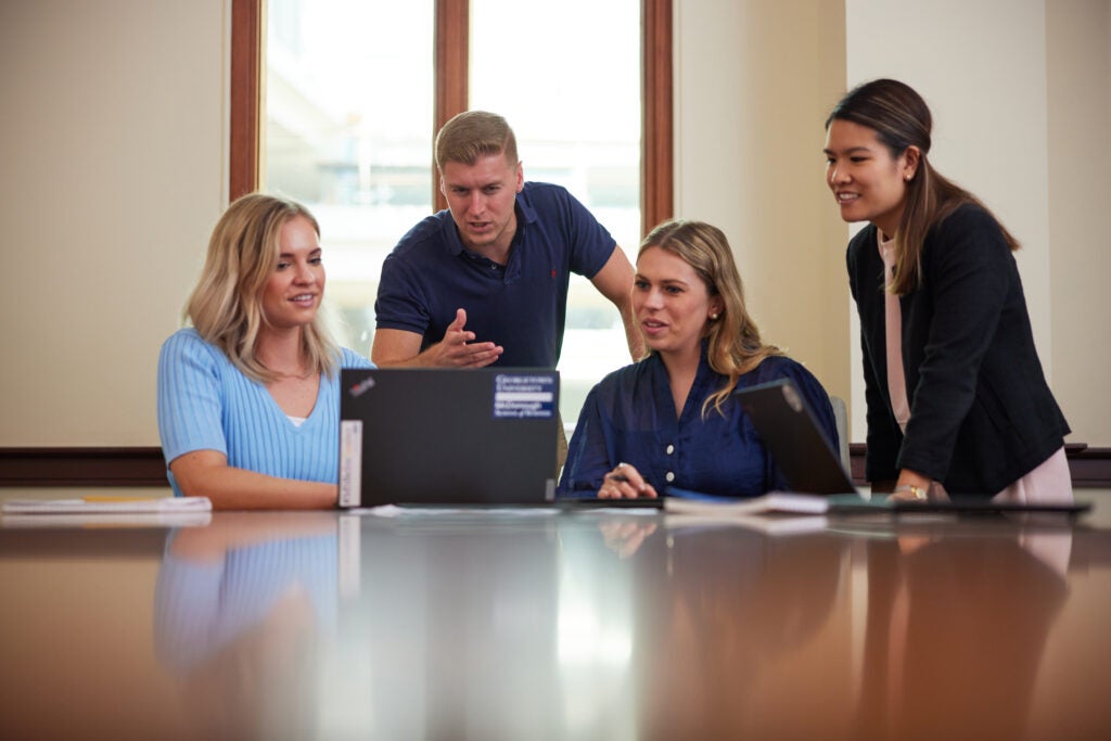 Group of Georgetown MSBA students looking at a laptop screen.
