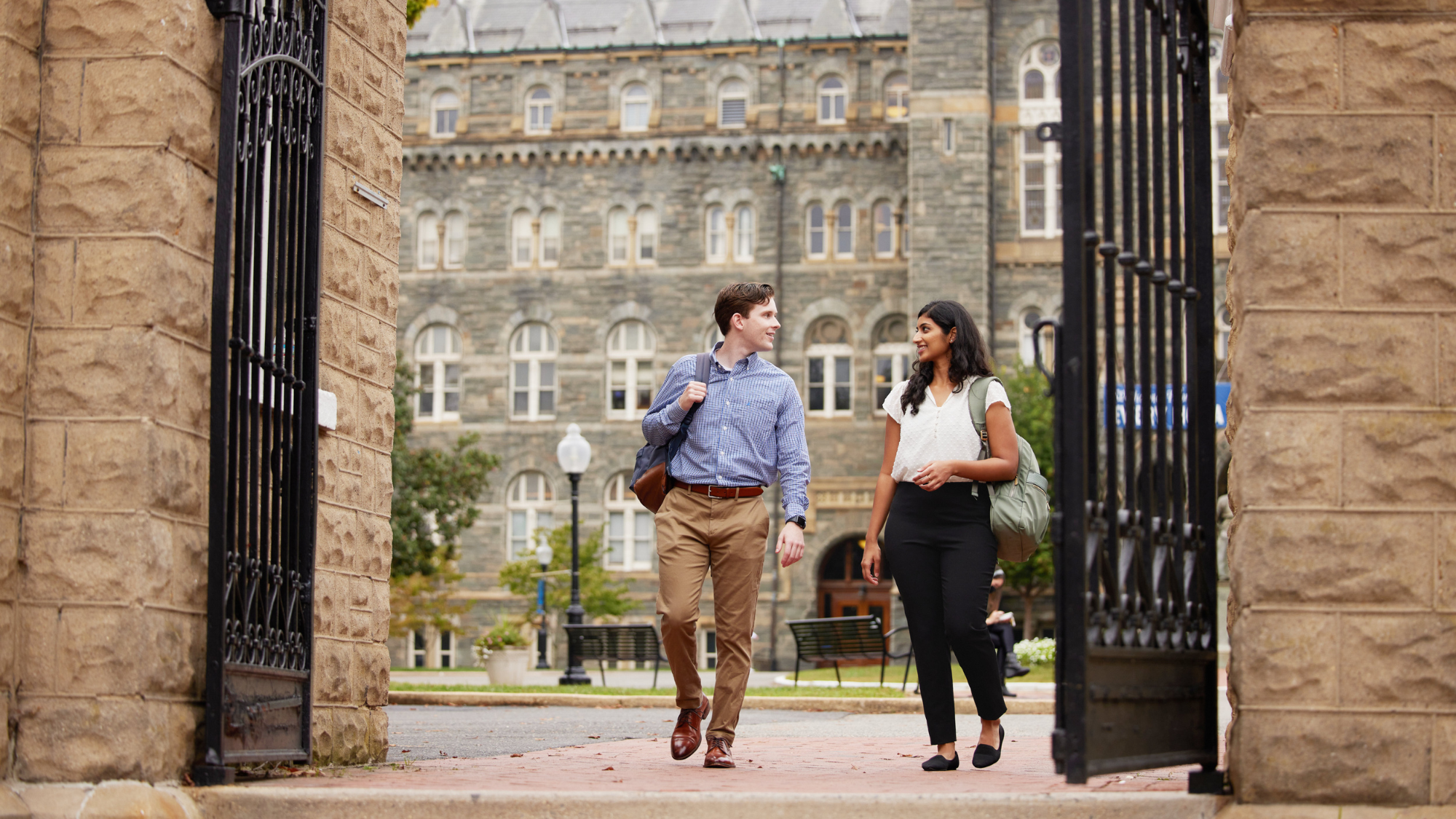 Two MiM students walking through the gates in front of Healy Hall at Georgetown