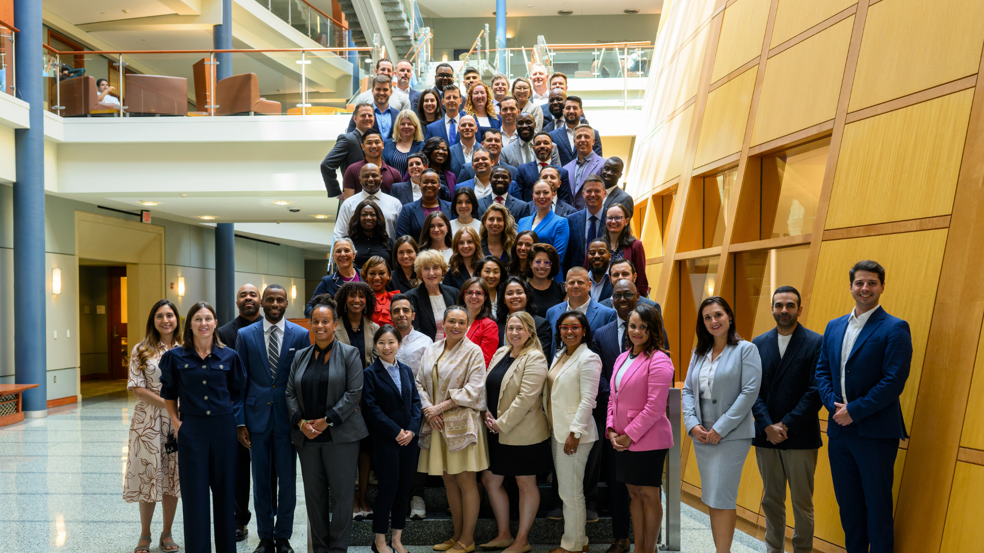 Executive MBA Incoming Class of 2027 poses on the stairs in the Hariri Building at Georgetown's McDonough School of Business
