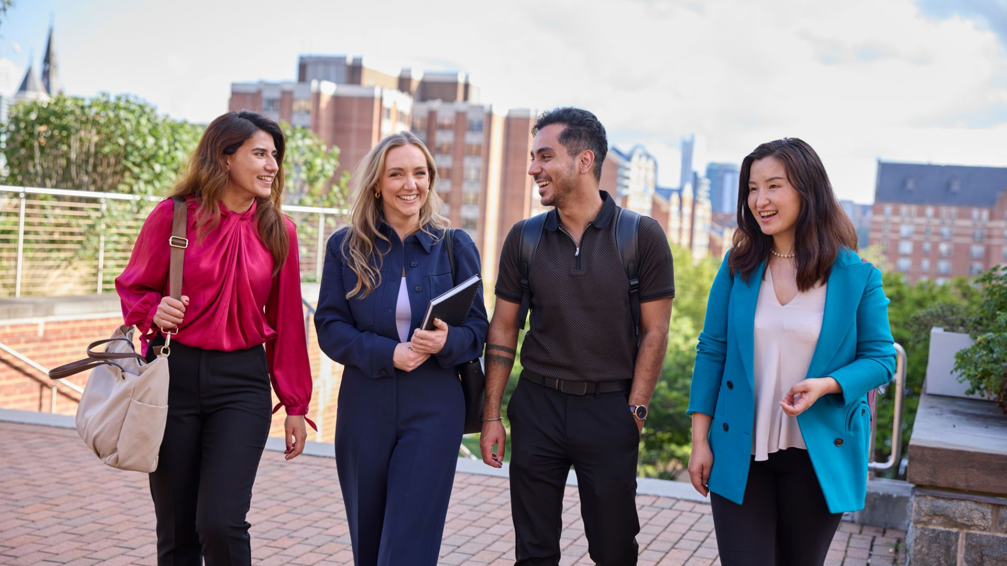 Four students in the Georgetown MBA program walk across campus in Washington, D.C.