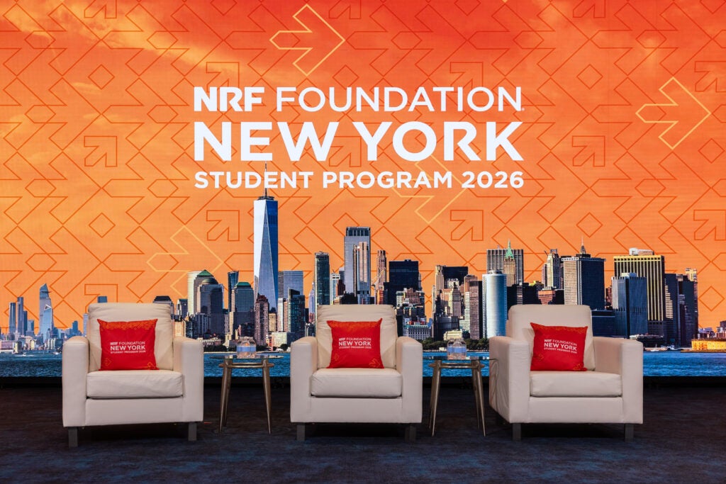 Stage with three empty armchairs and NRF Foundation Student Program logo in the background