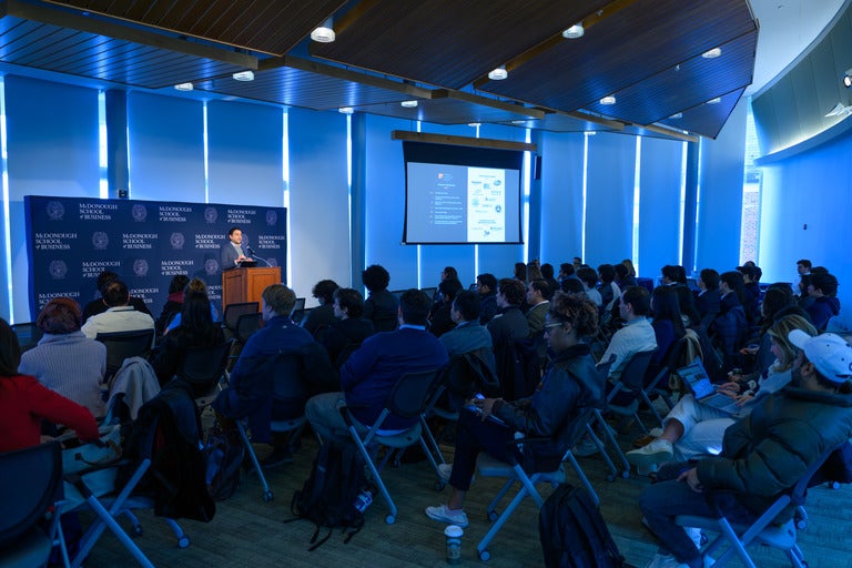 Keynote speaker talks to a full room in Fisher Colloquium at Georgetown McDonough