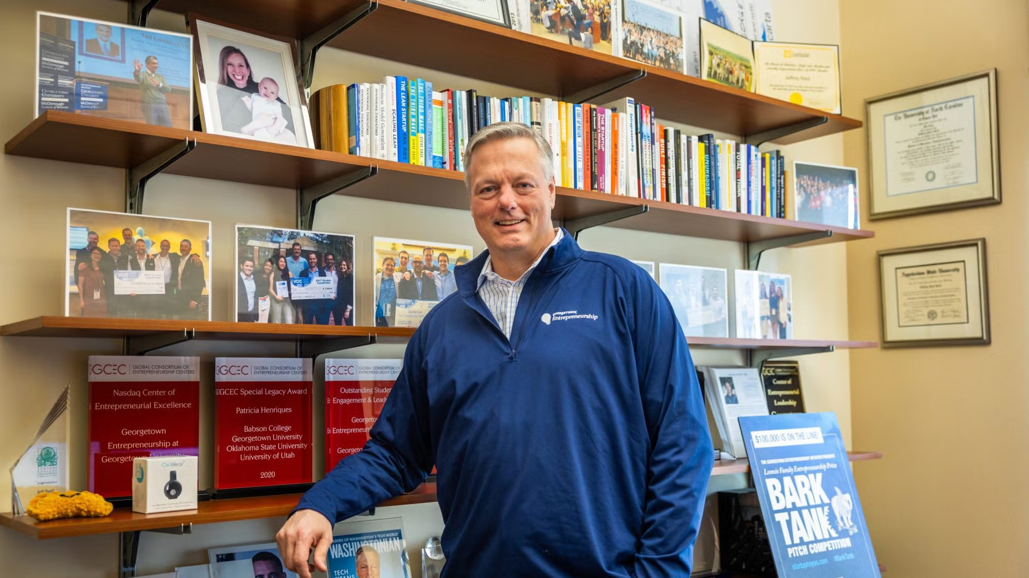 Jeff Reid stands front of bookshelf inside his office