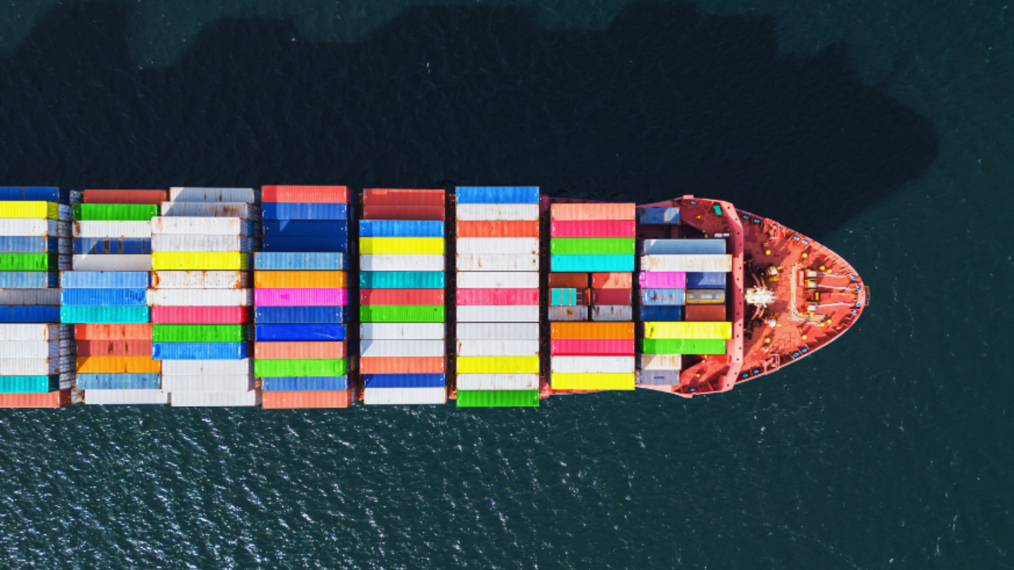 Ship with colorful shipping containers on board in water