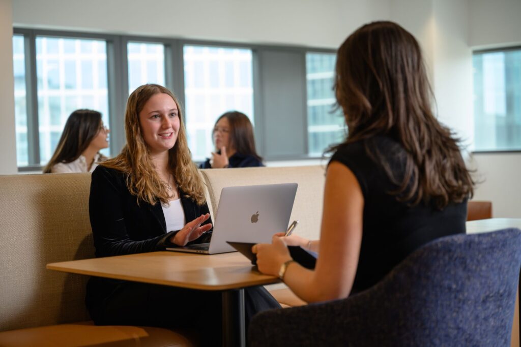 Two female MiM students sitting together.