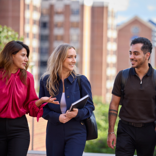 Students smiling and conversing while walking in the Hariri walkway.